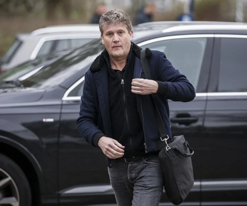 Alberto Stegeman naast geparkeerde auto's